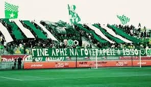 Ultras von Aris Limassol unterstützen ihr Team im Stadion mit Fahnen, Gesängen und Fan-Choreografie.