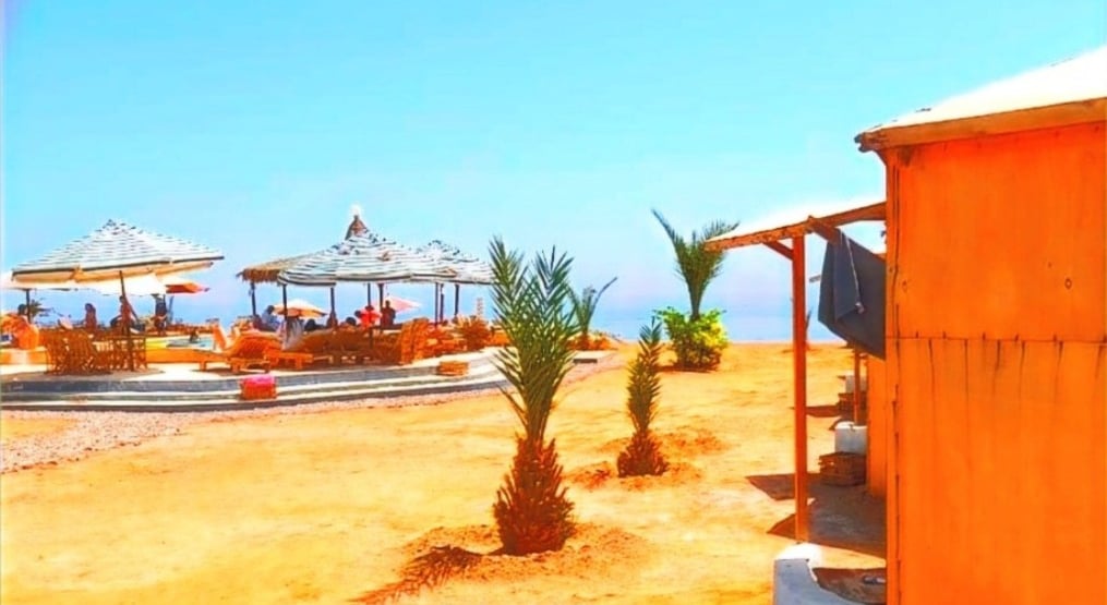 en strand med parasoller omkring en pool i Egypten 