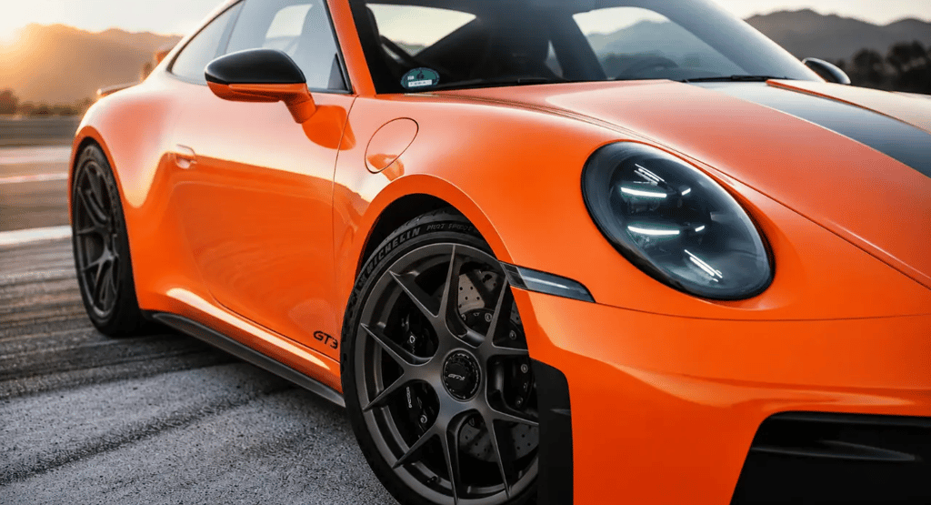 Porsche 911 laranja em pista durante mudança estratégica anunciada pelo novo CEO