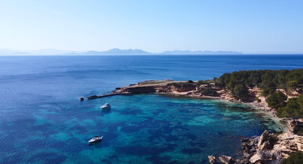 Barco en aguas cristalinas en la costa norte de Mallorca, Alcudia.
