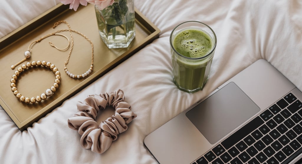 a laptop computer and a cup of coffee on a bed