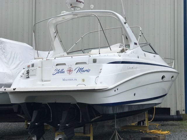 a boat sitting on a trailer with a boat in the background