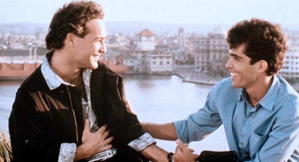 Actors Jorge Perugorria and Vladimir Cruz in a scene from Strawberry and Chocolate with a Havana cityscape background.