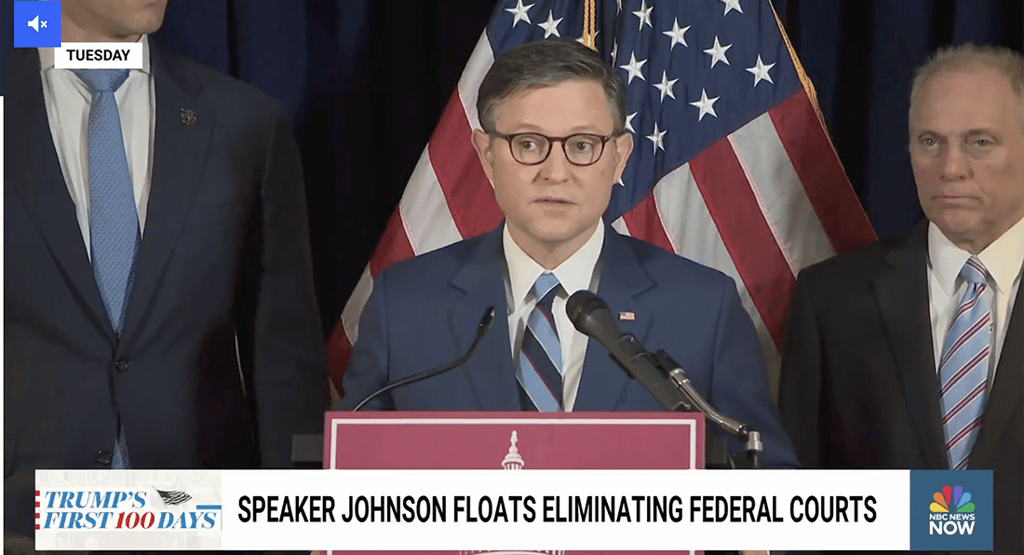 a man in a suit and tie standing in front of a microphone