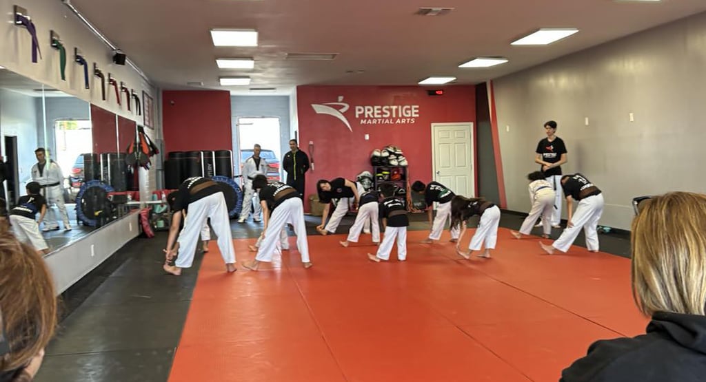 a group of people standing around a man in a karate pose
