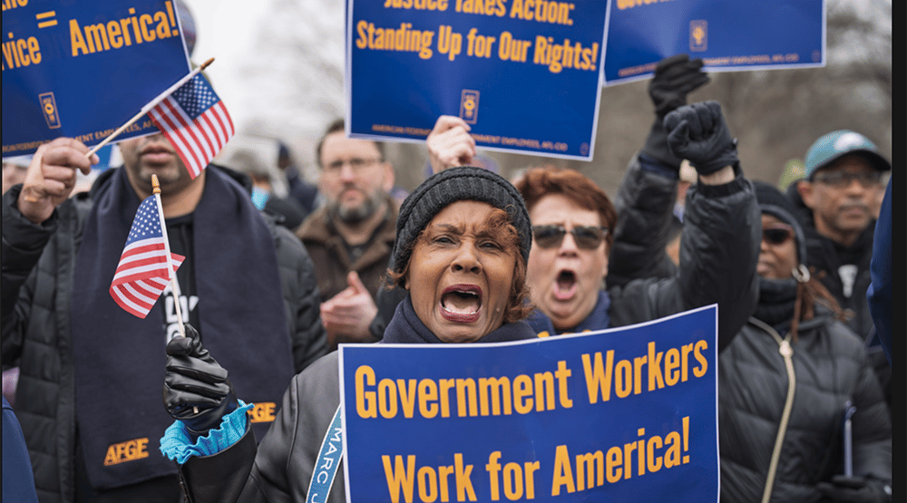 a woman holding a sign that says government workers