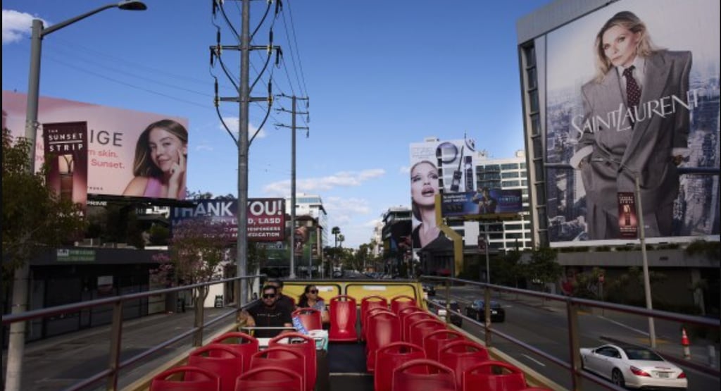 a bus stop with red chairs and billboards