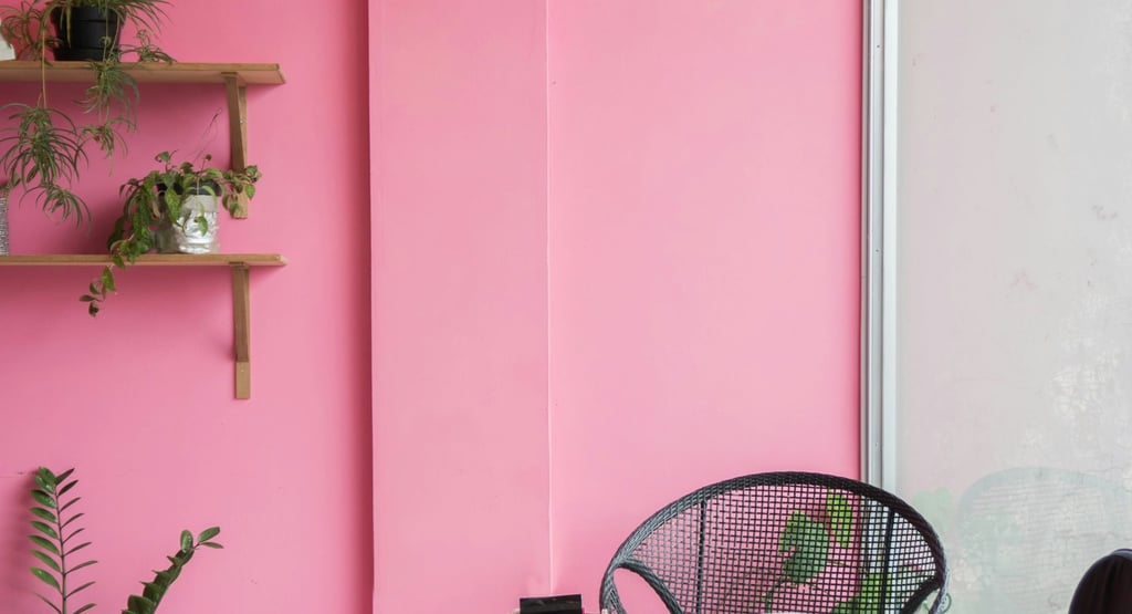 a pink room with a chair and a chair
