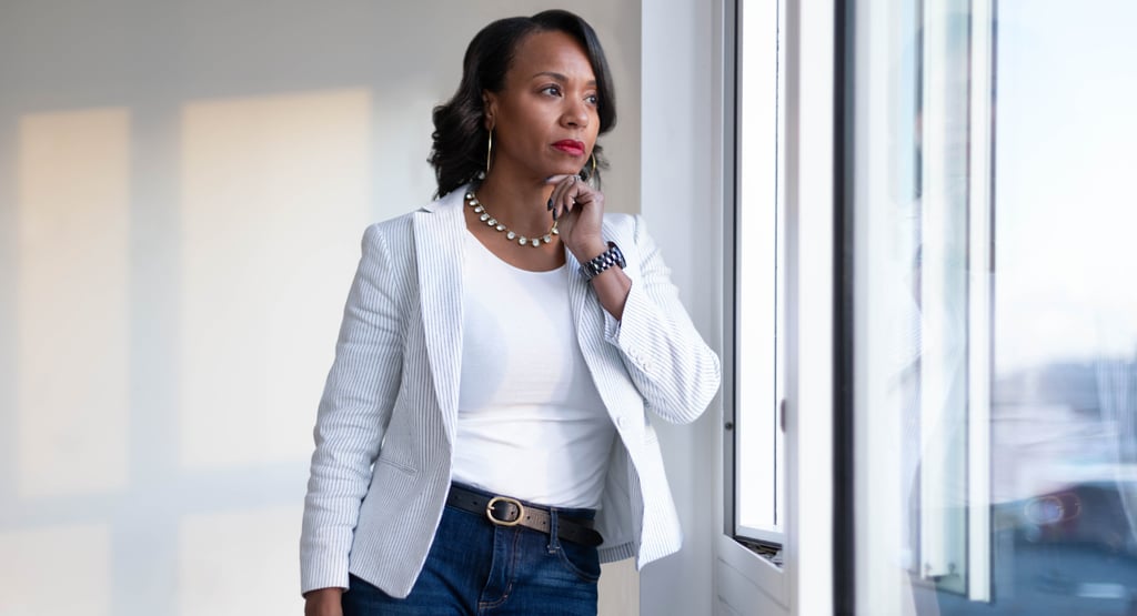 a woman in a white blazer and jeans jeans
