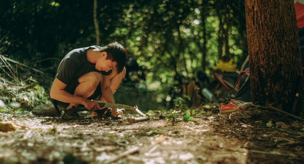 Person using firestarter in forest clearing, learning essential fire building survival skills