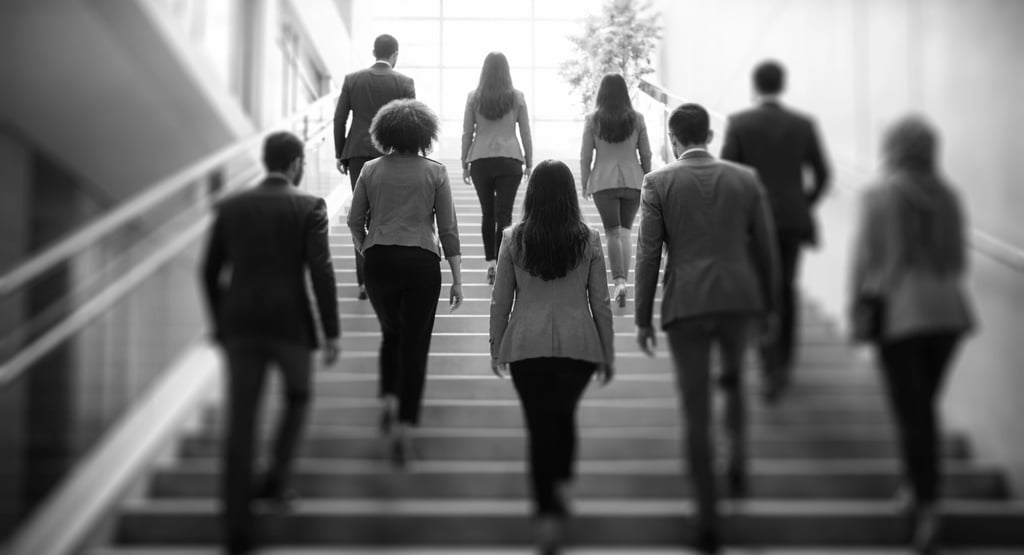 a group of diverse employees climbing a staircase together