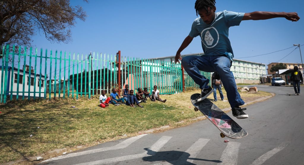 a man in a blue shirt is doing a trick on a skateboard