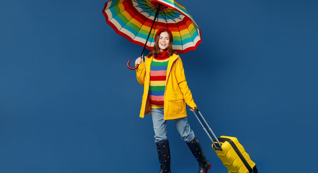 a woman in a yellow raincoat holding a suitcase and a suitcase