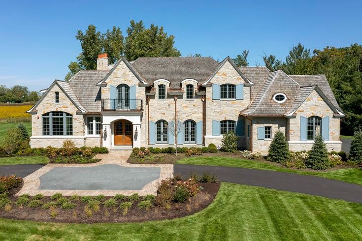 Stone French country custom home with shingle roof in western Chicago suburbs