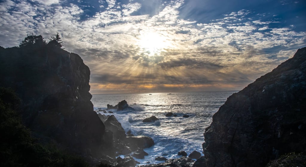 Sunlight breaks through clouds over rocky cliffs and turbulent sea, symbolizing balance 