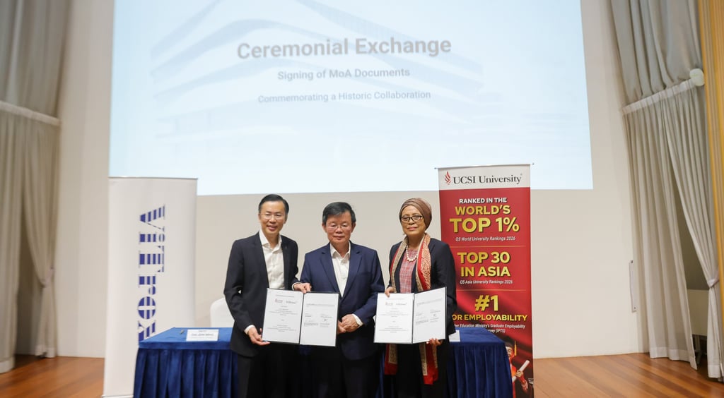 Representatives holding signed MoA documents at the UCSI University and ViTrox ceremonial exchange event.