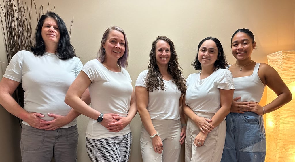 5 women standing in front of a wall