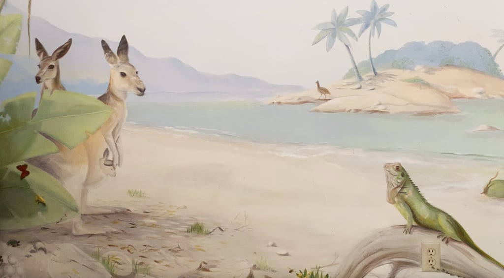 Hand-painted mural scene with kangaroos by the shore and an iguana basking in light—part of an Australian wildlife mural