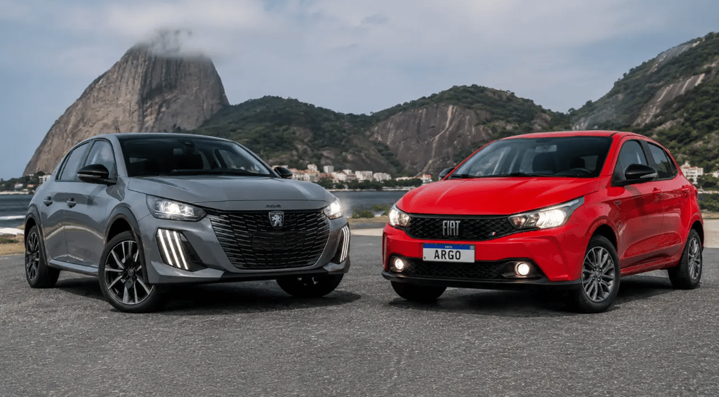 Peugeot 208 Hybrid cinza e Fiat Argo vermelho lado a lado em cenário externo panorâmico.