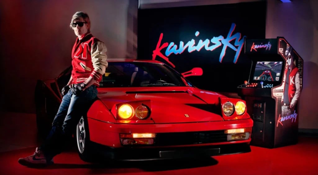 Kavinsky e sua Ferrari Testarossa ao fuundo um fliperama