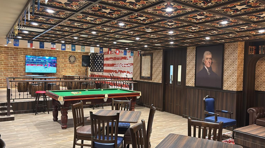 American themed game room with a pool table, dartboard, and patriotic decor.