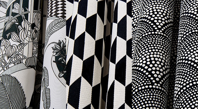 Black and white patterned upholstery fabric samples featuring geometric, floral, and dotted designs.