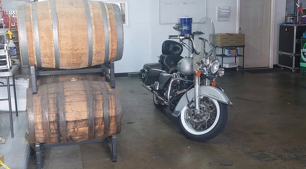 a motorcycle parked in a brewery with a barrel of beer