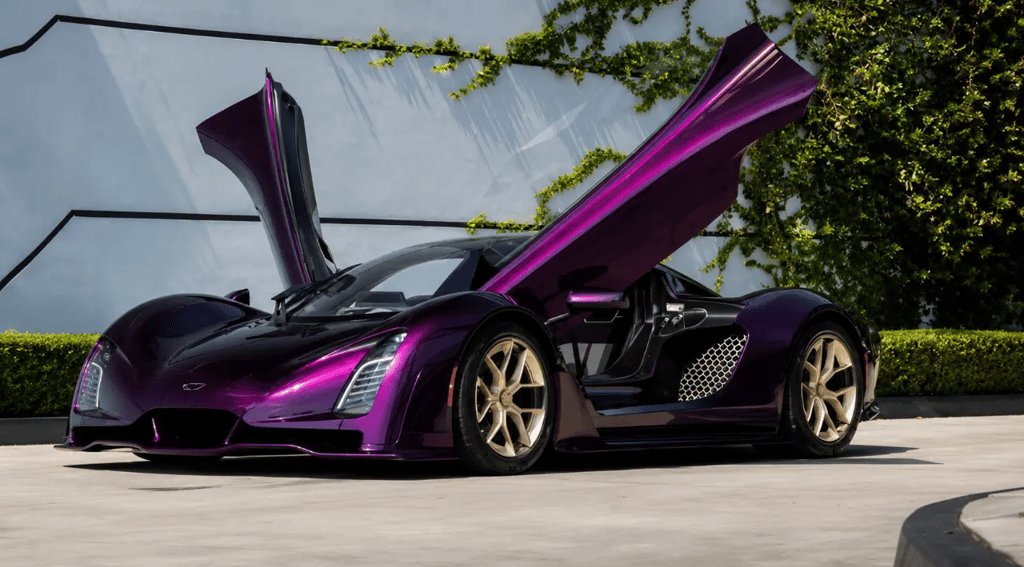 Czinger 21C VMax roxo com portas abertas e detalhes dourados em frente a parede moderna
