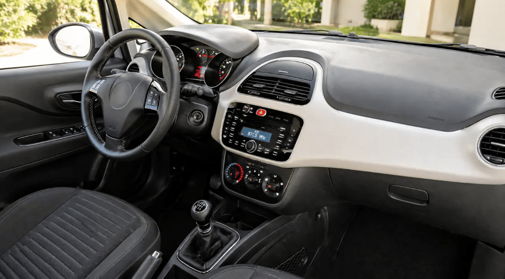 Interior do Fiat Punto 2015 durante o dia mostrando acabamento e câmbio manual