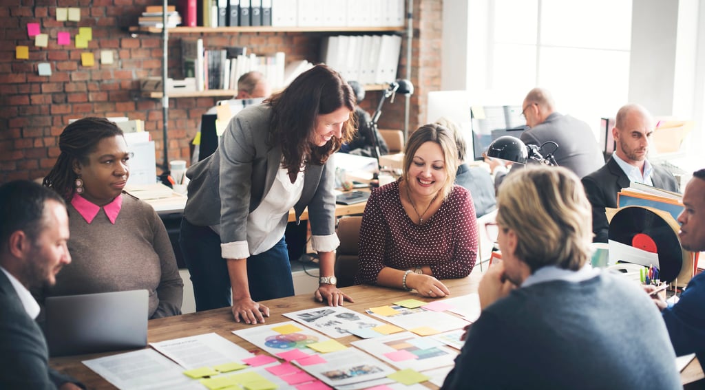 Diverse creative team collaborating on a marketing project in a modern open-plan office.