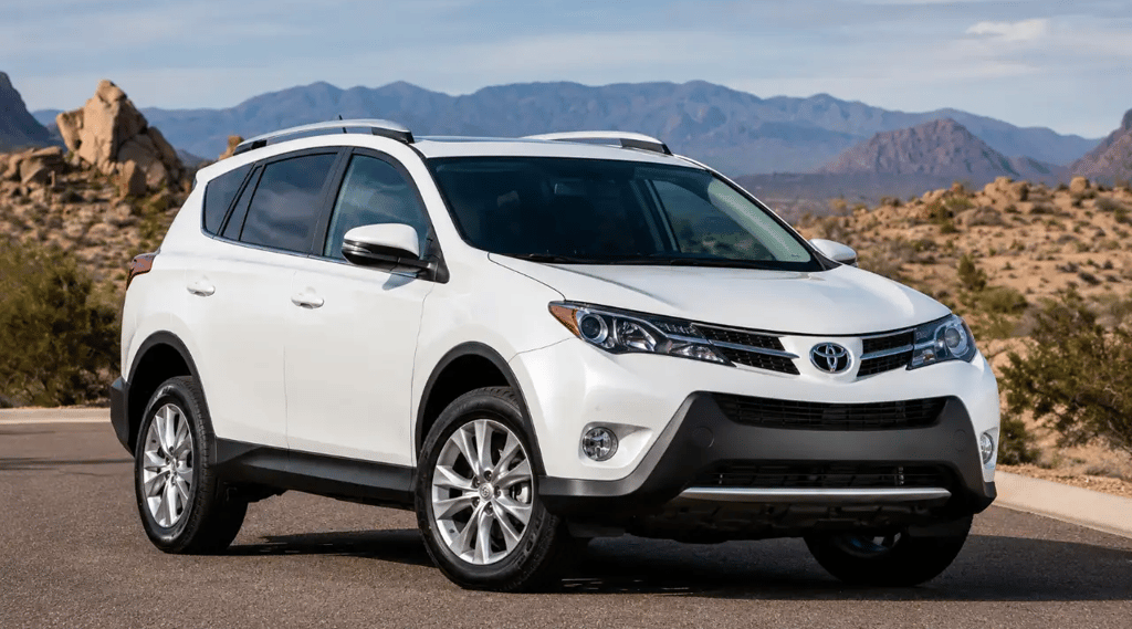 Toyota RAV4 2014 branco em estrada com cenário montanhoso ao fundo