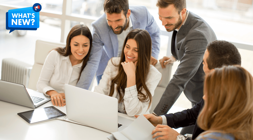a group of people sitting around a table with laptops and a text saying What's New?