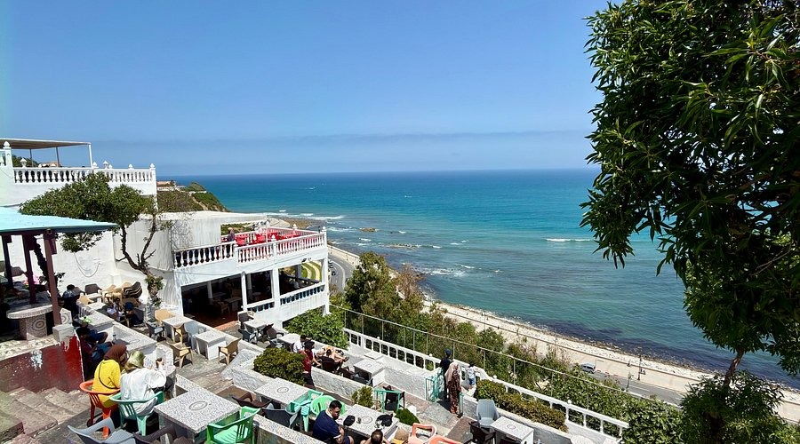 Outdoor terrace restaurant overlooking the Mediterranean Sea and coastline in Tangier, Morocco.