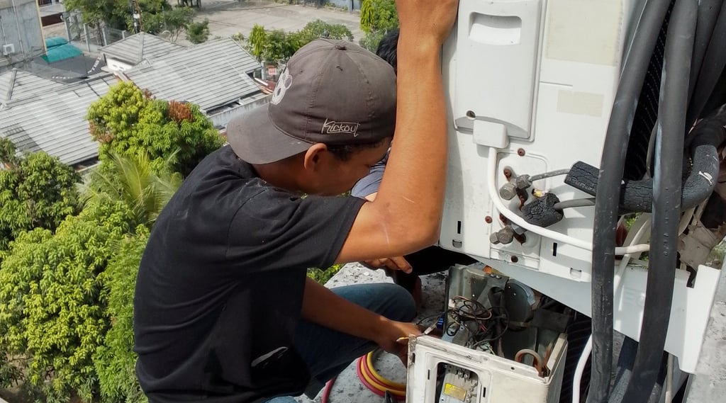 a man is fixing a machine on a roof