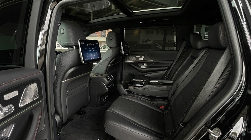 Luxury SUV interior with black leather seats, rear entertainment screens, and a panoramic sunroof.