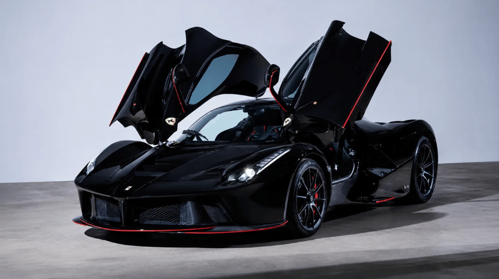 Ferrari LaFerrari preta com portas abertas em estúdio e detalhes vermelhos esportivos
