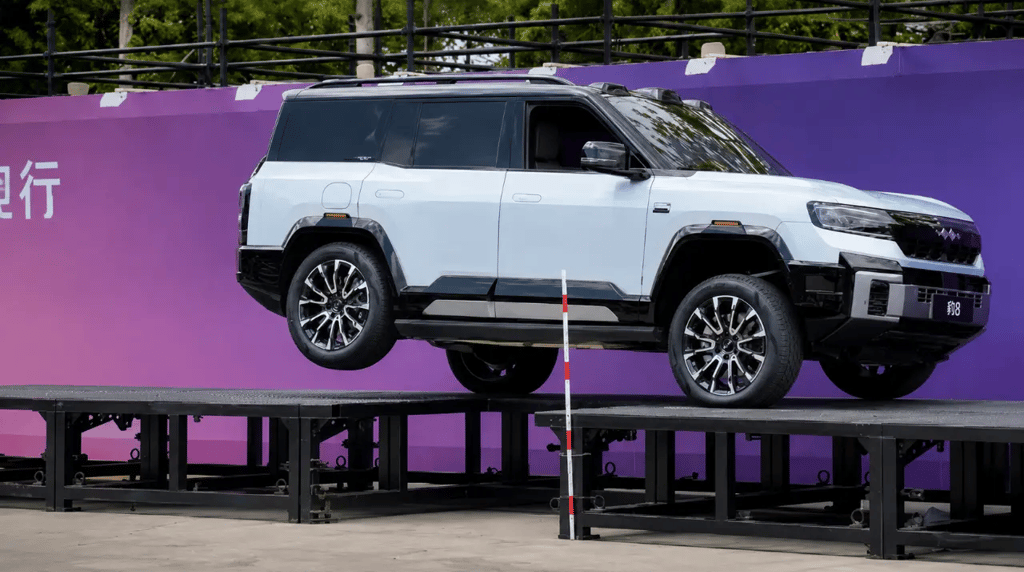 SUV chinês da BYD levantando uma roda durante demonstração de suspensão inteligente