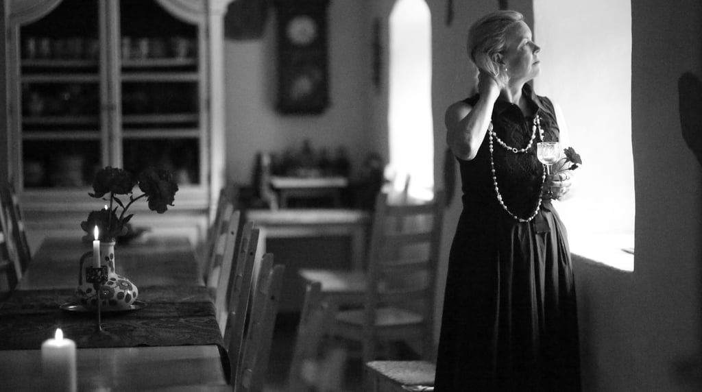 a woman in a long dress standing in a room