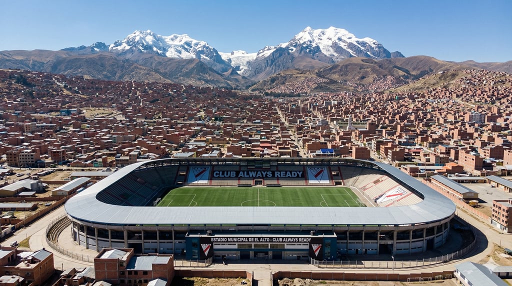 Estádio Municipal de El Alto cercado por casas e montanhas nevadas ao fundo, sob o céu azul da Bolívia.
