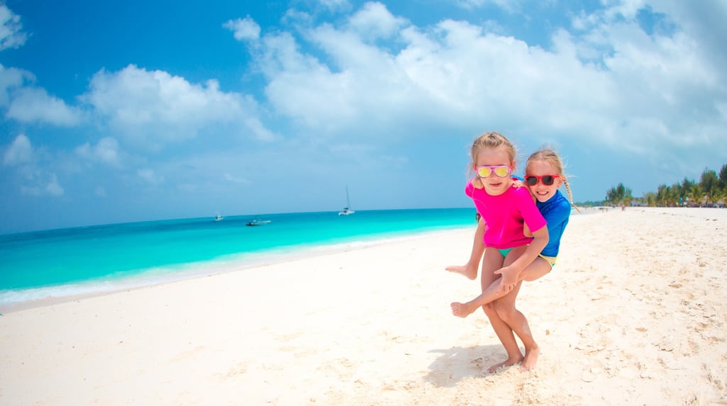 Two children playing on a white sand beach in the Dominican Republic