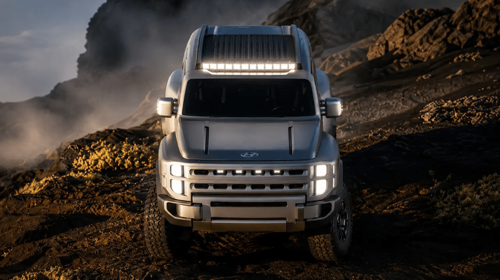 Caminhonete elétrica Hyundai em terreno rochoso com visual robusto e iluminação off-road