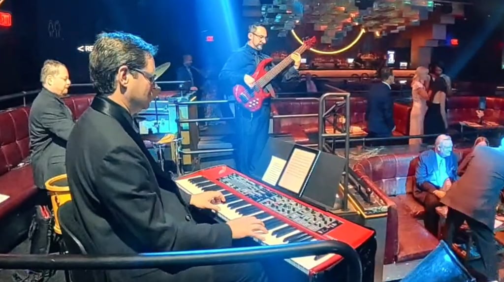 Jozef Bobula on red 6-string bass with pianist and drummer, performing live for formal guests at The Palms Las Vegas.