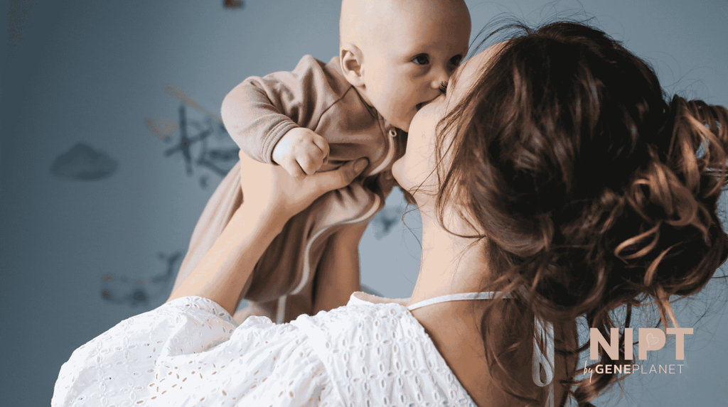 una madre levanta a su bebé en sus brazos feliz de hacerse la prueba NIPT en Colombia
