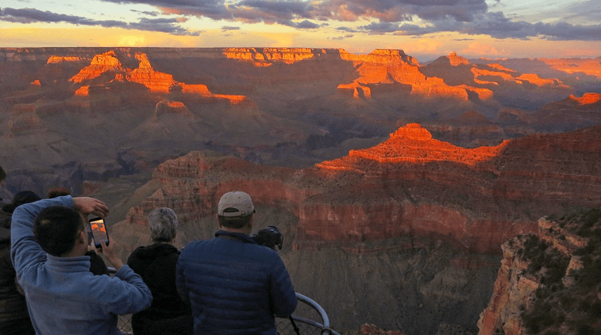 Tourist at Grand Canyon North Rim at Sunset
