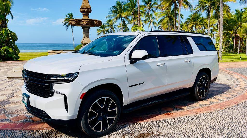 a white suv parked in front of a fountain