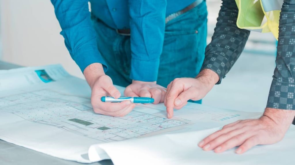 dos personas con unos planos de construcción