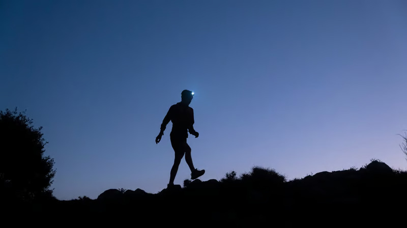 a person walking on a hill with a blue sky in the background