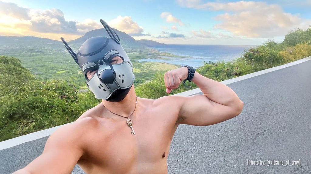 A shirtless man in a pup mask flexing and posing on Hawaii vista. @kitsune_of_troy