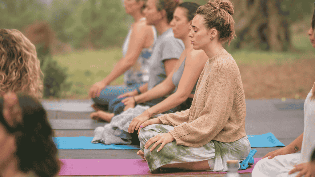 group of people meditating outside