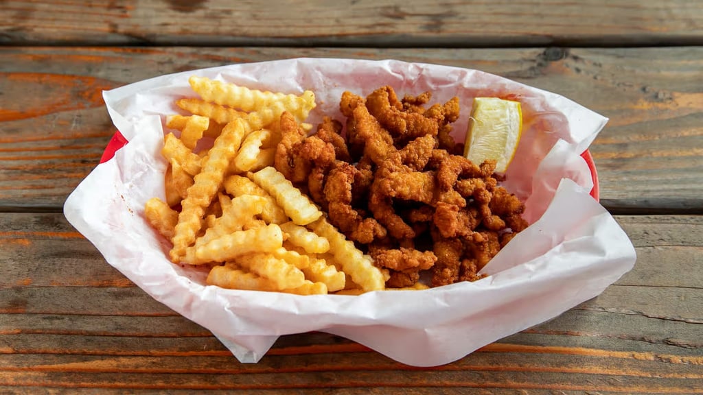 Fried clam strips with crinkle‑cut fries and a lemon wedge from Captain’s Galley